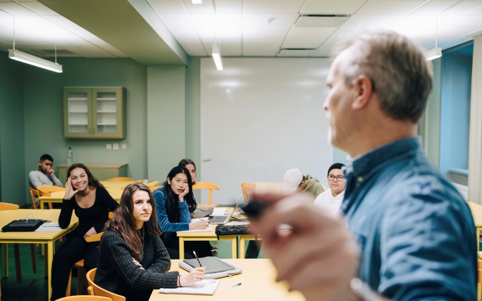 Lärare står framför elever i ett klassrum